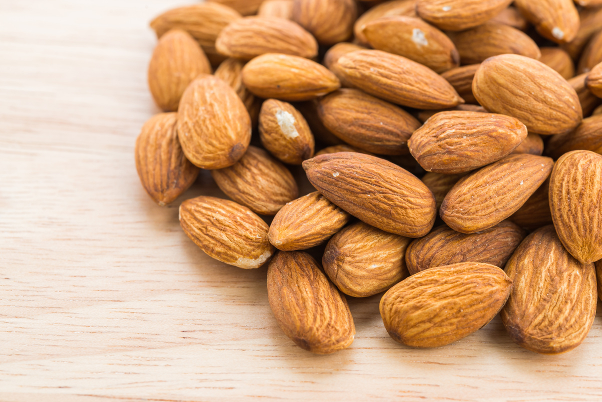 Heap of Almond Nuts on Wooden Background